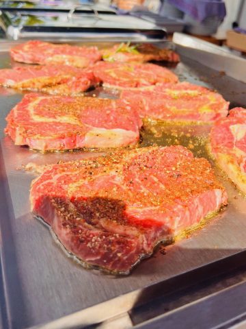 Gewürzte Steaks auf dem Grill.