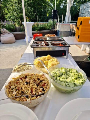 Buffet im Freien mit Pasta, Salat und Grillgerichten.