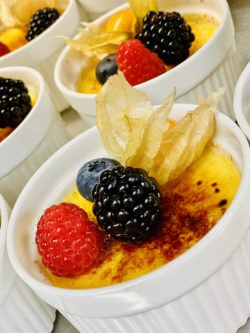 Cremige Crème brûlée mit frischen Beeren.